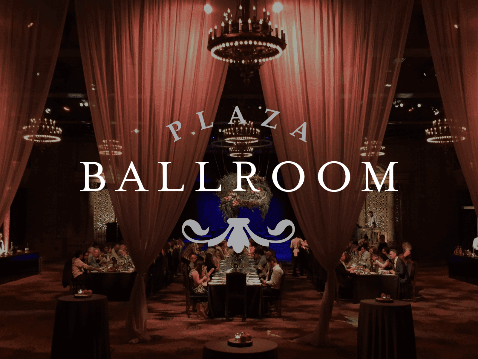 Elegant Plaza Ballroom event space with chandeliers, drapery, and guests.