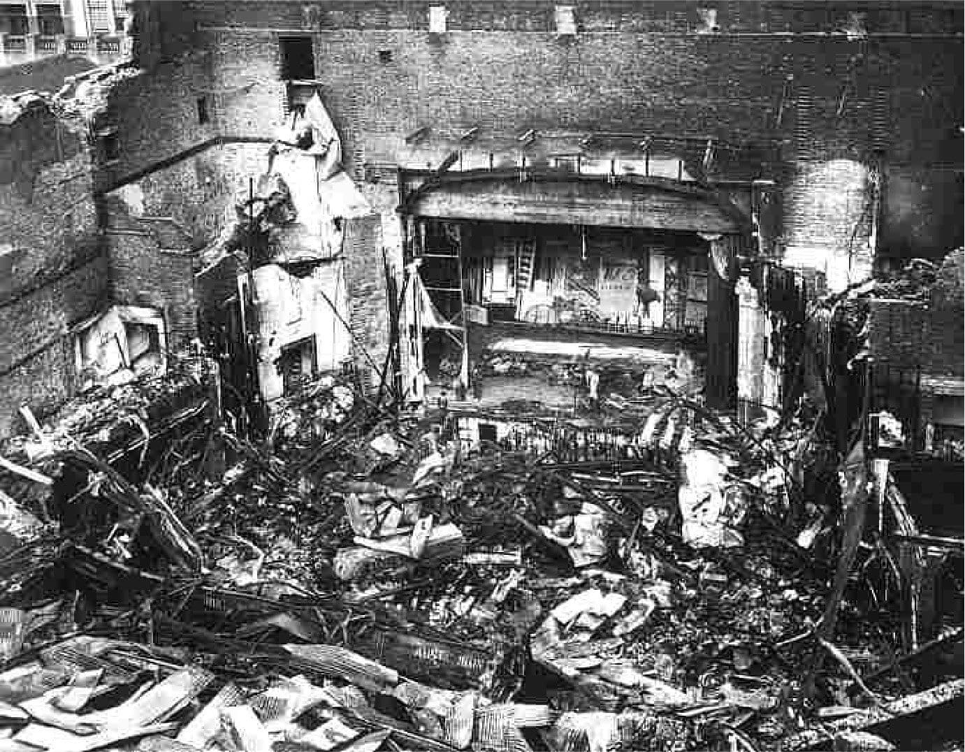 Devastated theatre interior, filled with debris and rubble after significant damage.