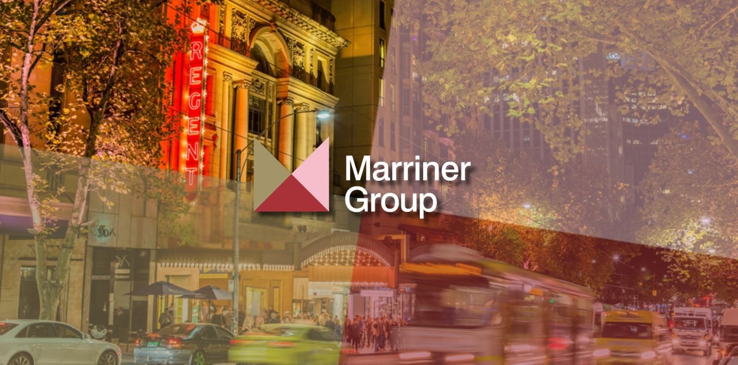 Marriner Group logo overlaid on a vibrant night cityscape with neon lights.