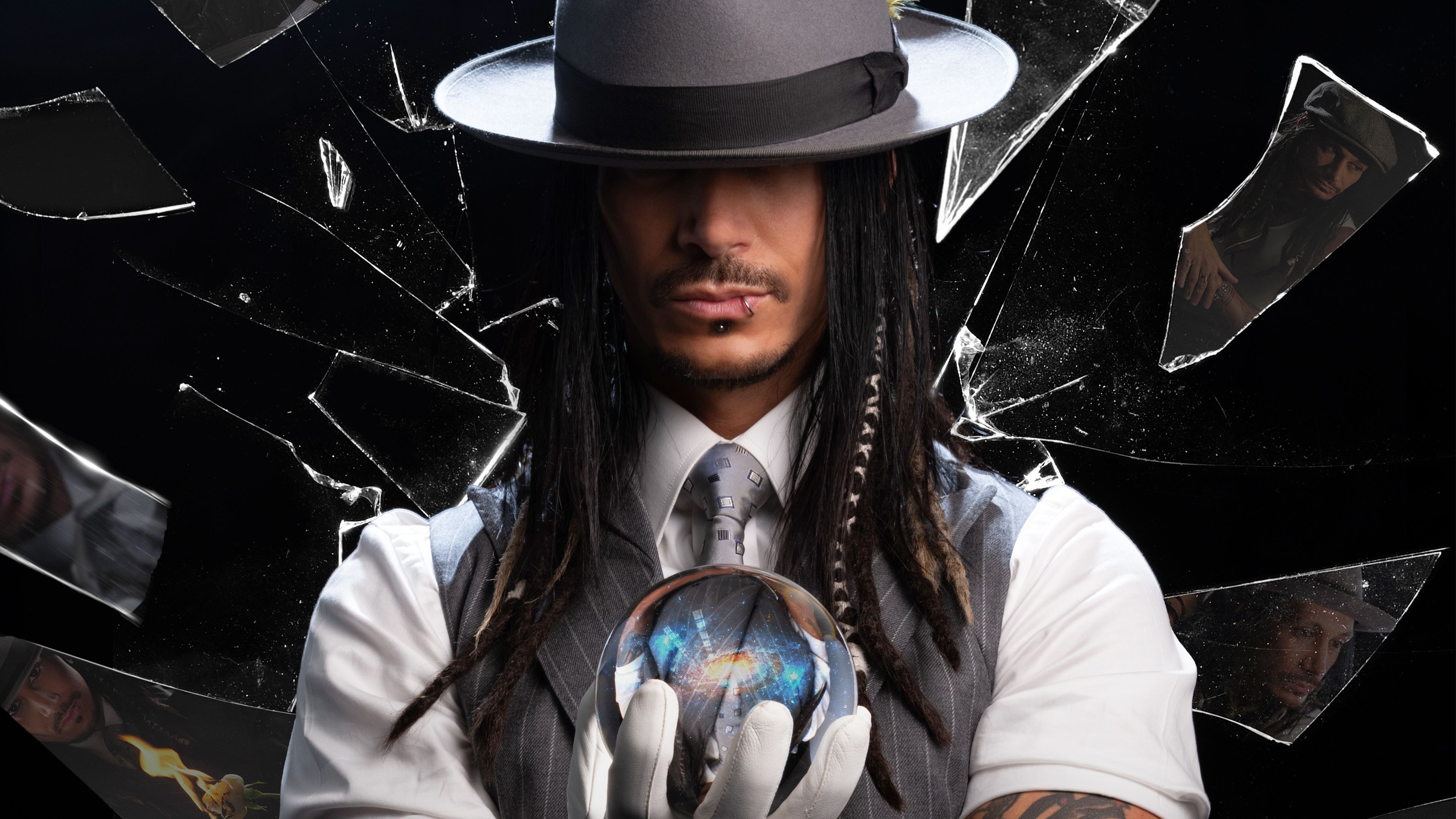 Man in fedora and vest holds glowing orb amidst shattered glass fragments.