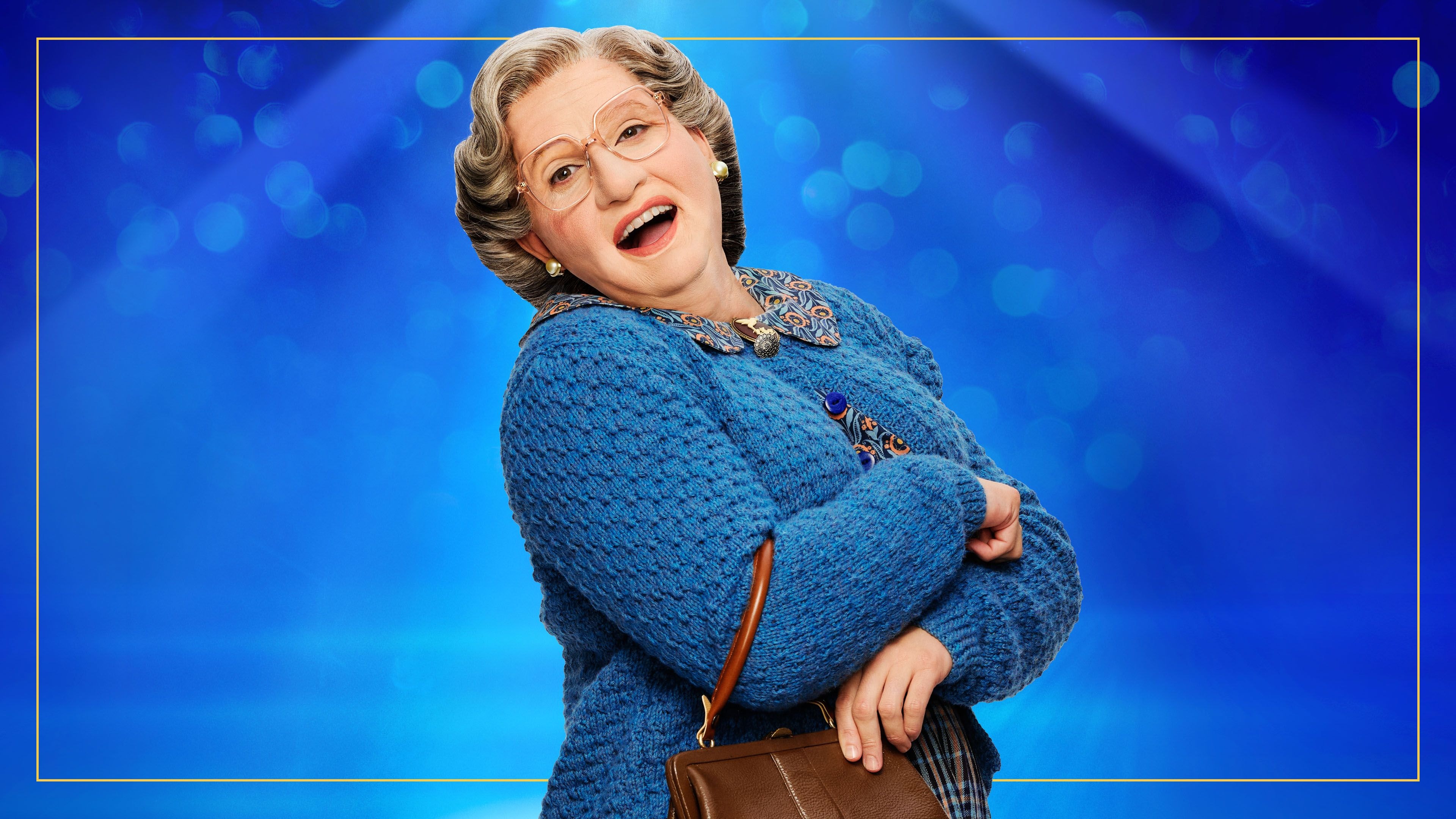 An elderly woman in glasses and a blue cardigan smiles, holding a brown purse.
